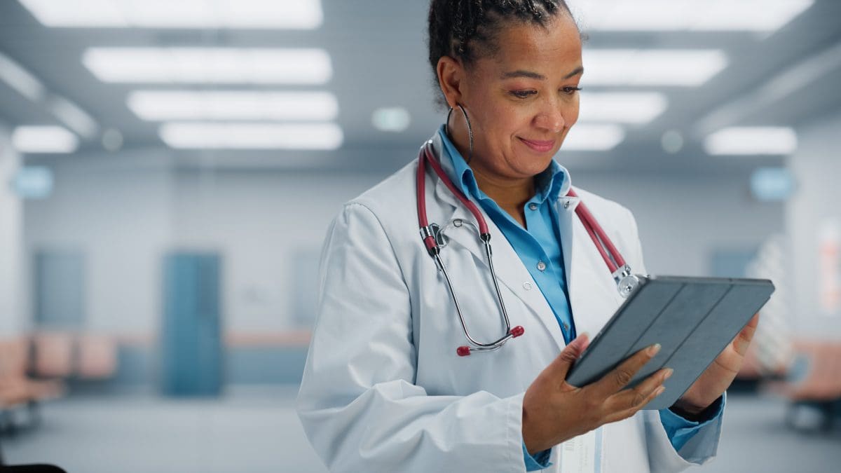 Smiling doctor looking at a tablet