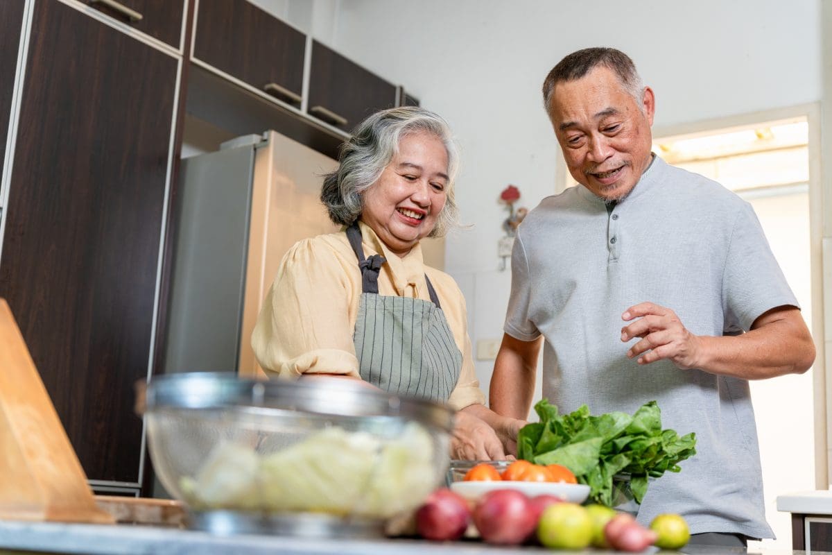 Cheerful elderly couple cooking a healthy meal together