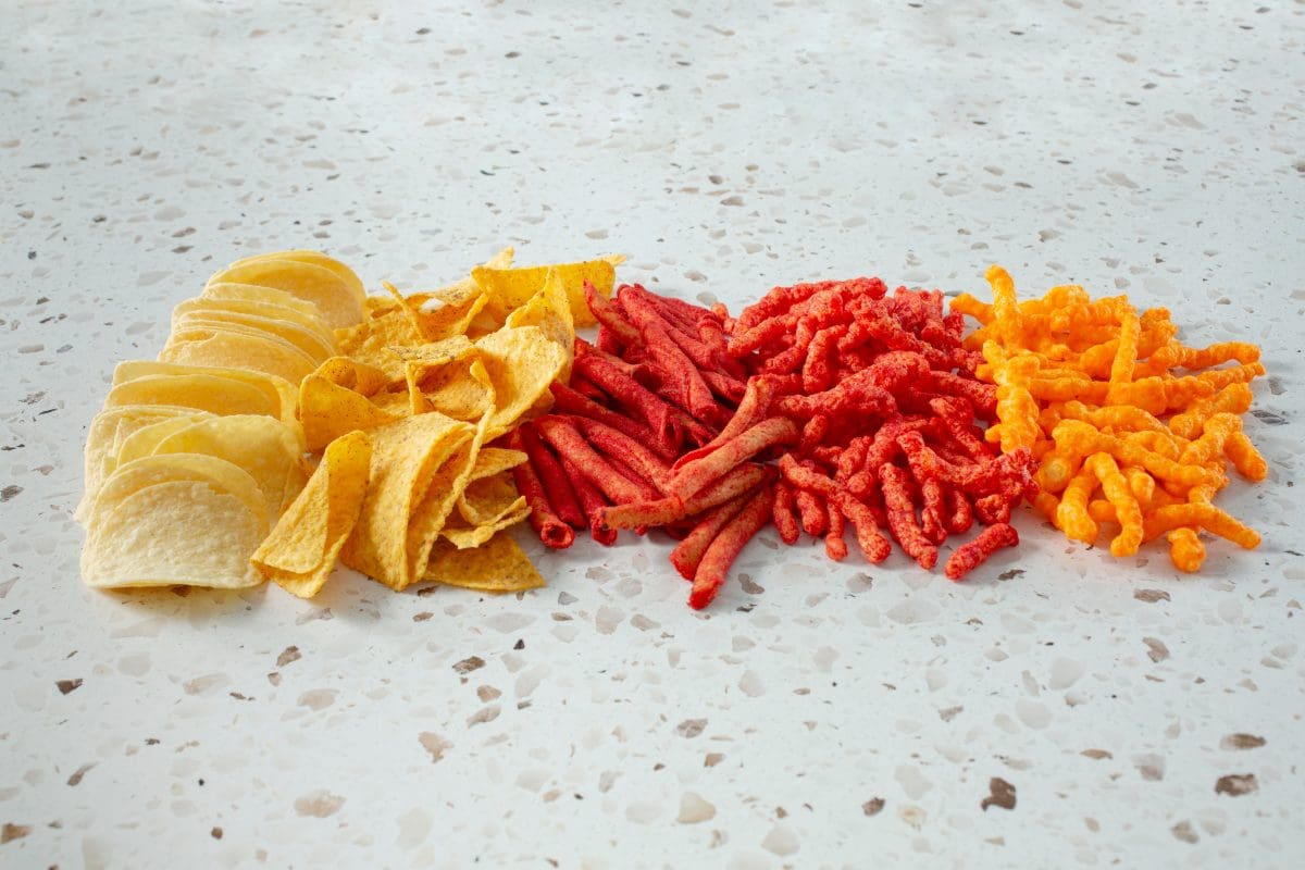 Assorted ultraprocessed chips and snack foods laying on a counter