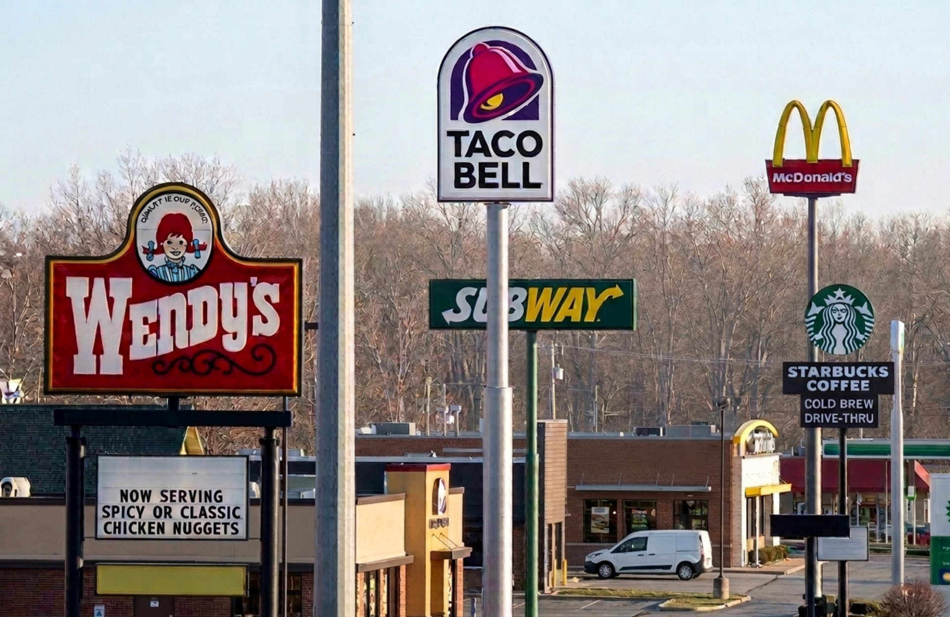 A busy street with several fast food restaurants in close proximity