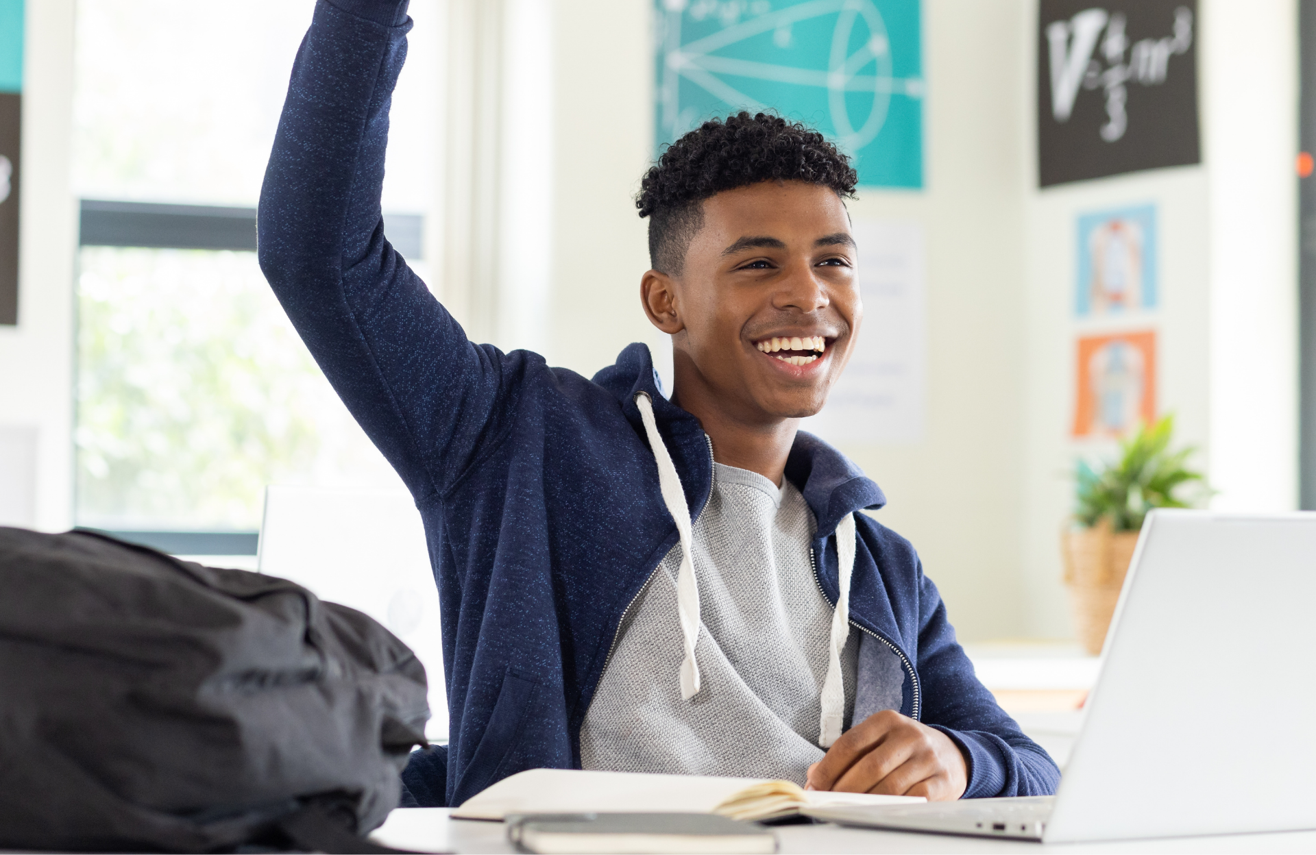 High school student raising his hand in class